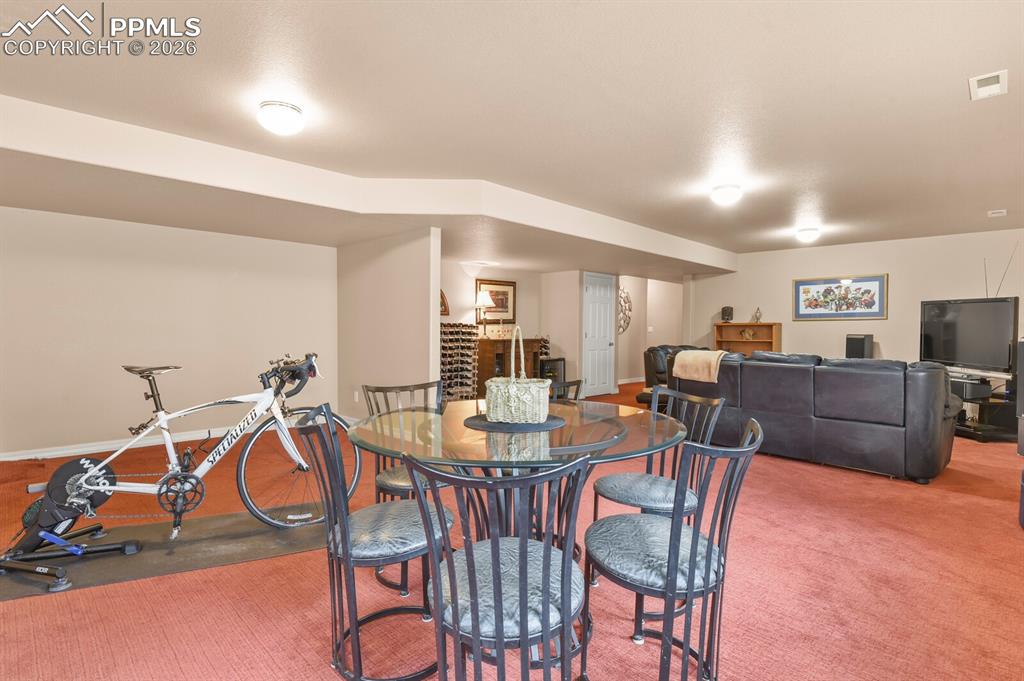 Image 31 of 42: Basement Family room space showing the exercise area and card/game table.  