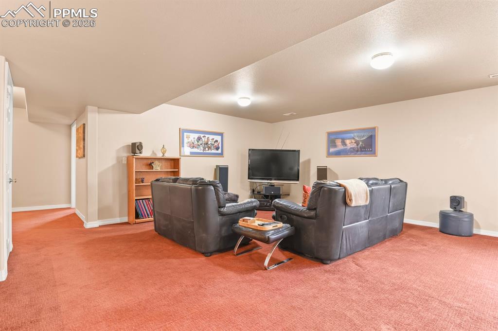 Image 33 of 42: Carpeted living room with baseboards