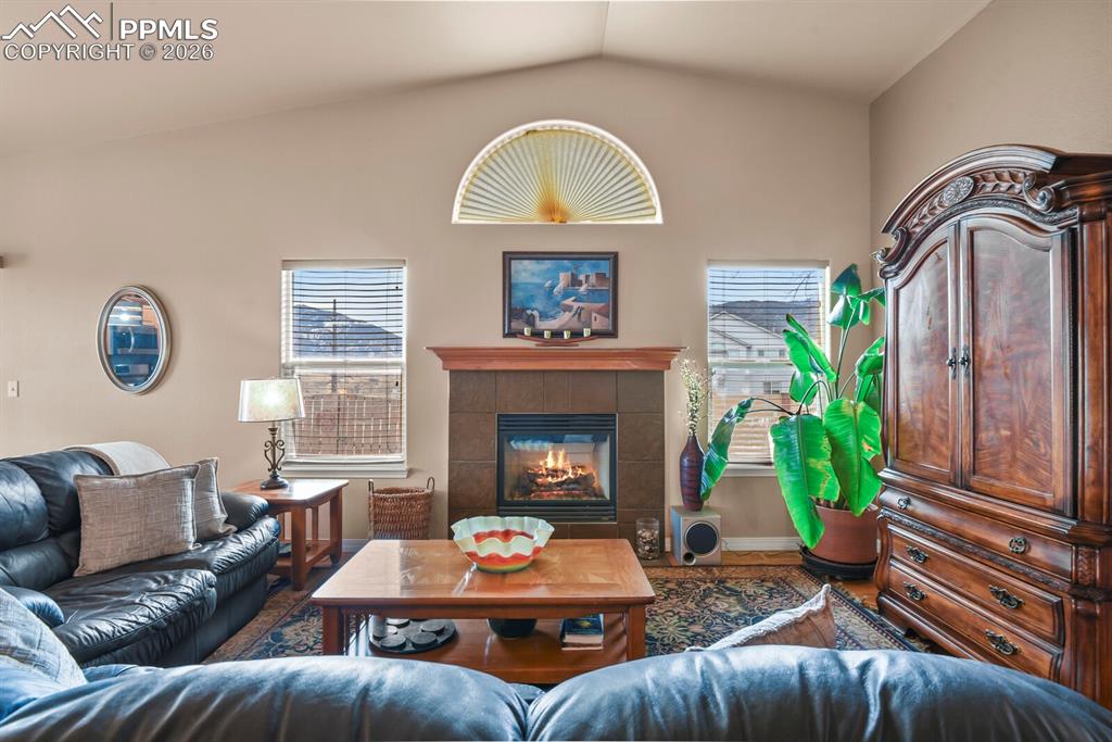 Image 7 of 42: Living room featuring two large windows for natural light, a fireplace, and