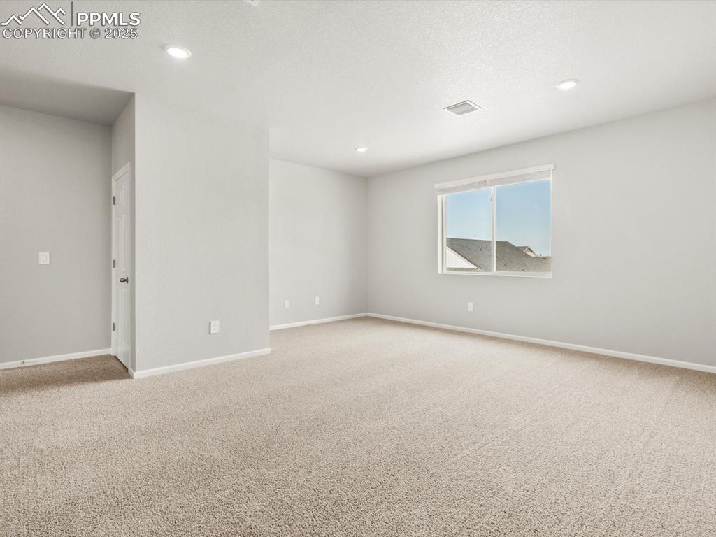 Image 17 of 26: Unfurnished room featuring light carpet, recessed lighting, and a textured