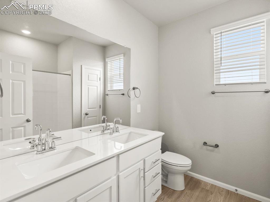 Image 21 of 26: Full bath with light wood-style floors, plenty of natural light, double van