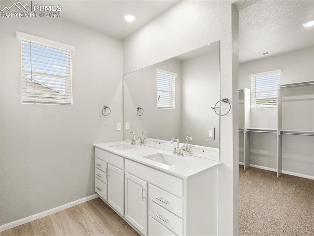 Image 22 of 26: Full bathroom with double vanity, plenty of natural light, a spacious close