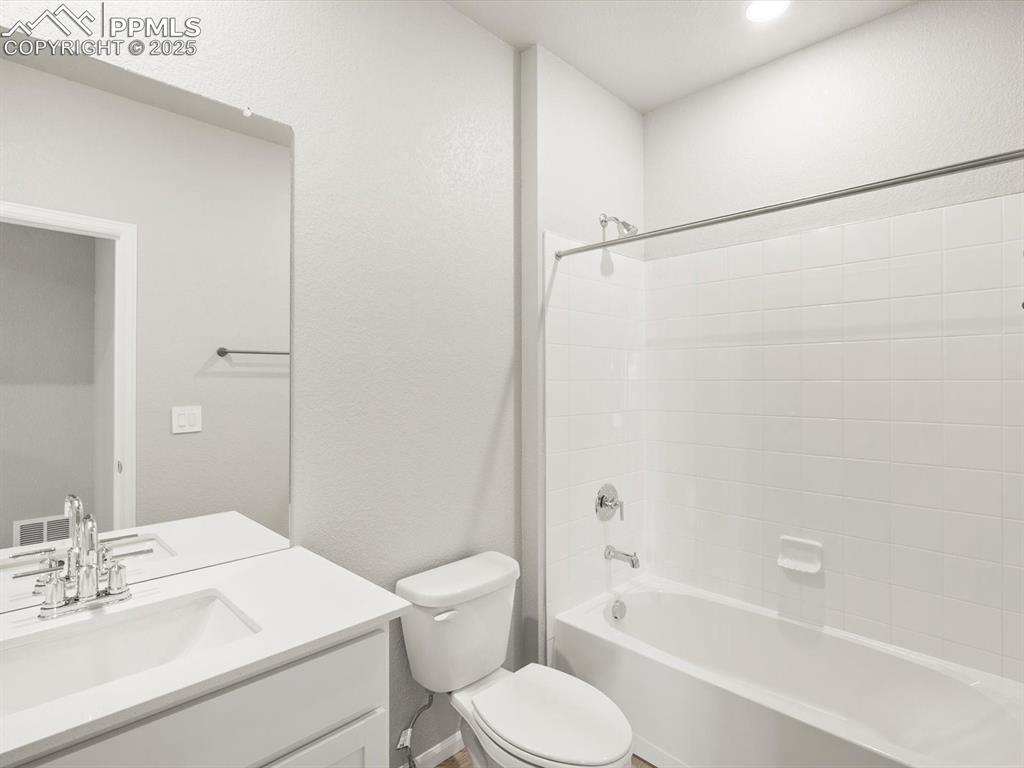 Image 24 of 26: Full bath featuring a textured wall, bathing tub / shower combination, and