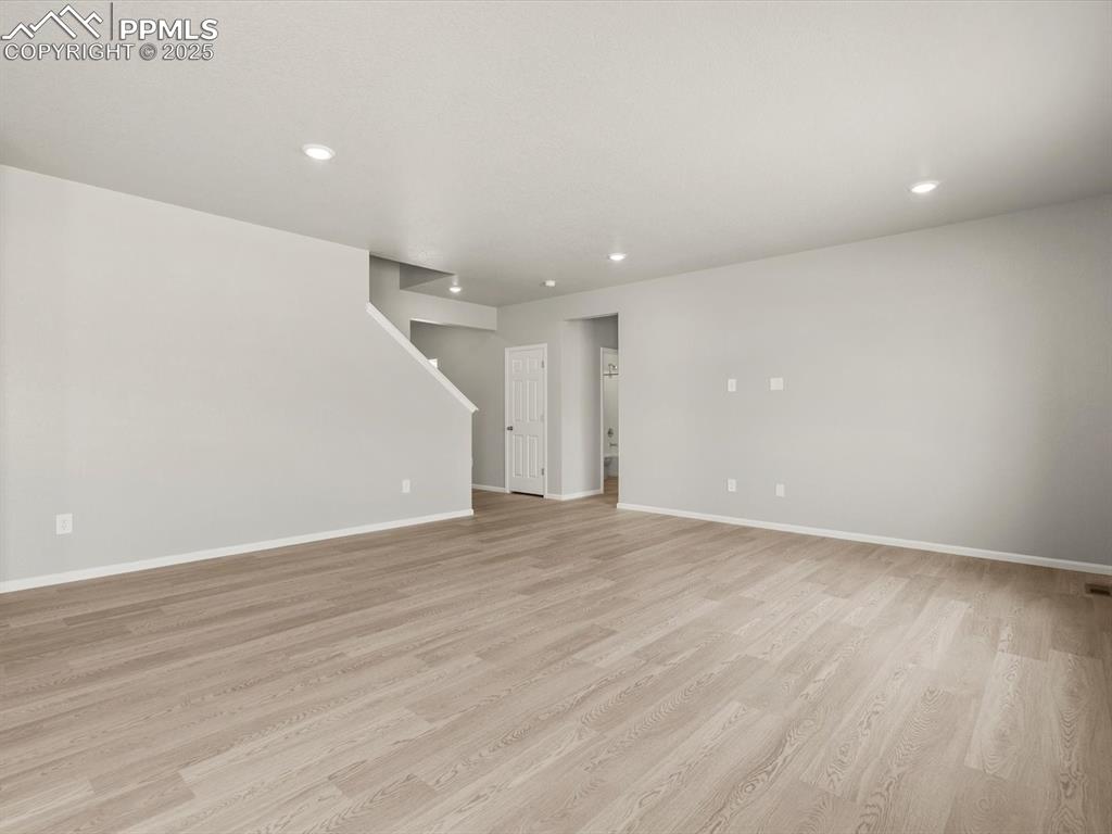 Image 6 of 26: Unfurnished living room with light wood-style flooring and recessed lightin