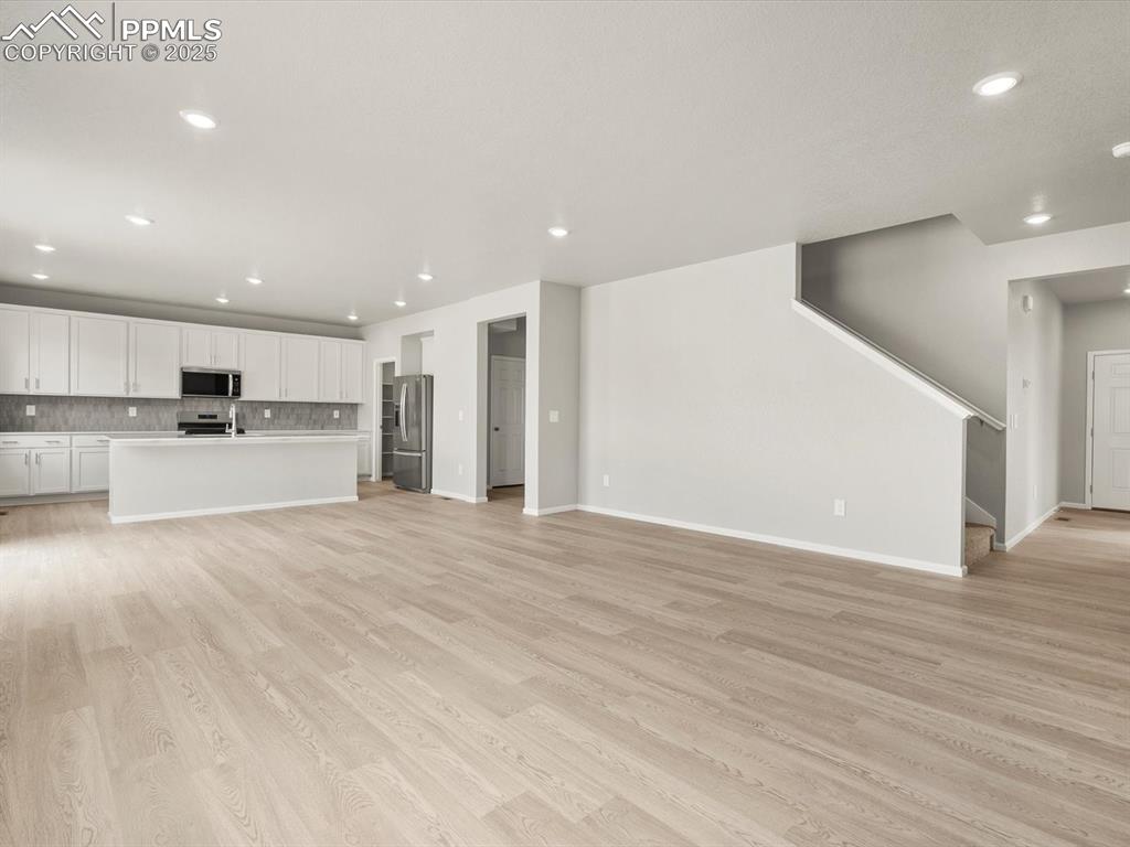 Image 7 of 26: Unfurnished living room with recessed lighting, light wood-type flooring, a
