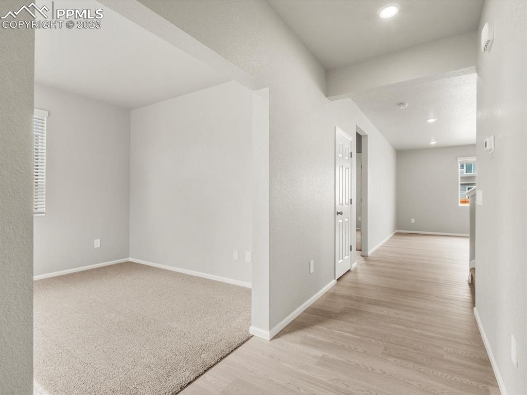Image 9 of 26: Corridor with light wood finished floors and recessed lighting