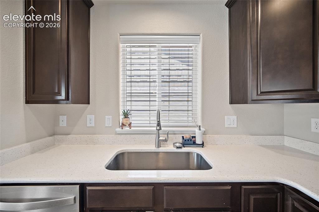 Image 12 of 49: Kitchen features a stainless steel sink with a gooseneck faucet, light-tone