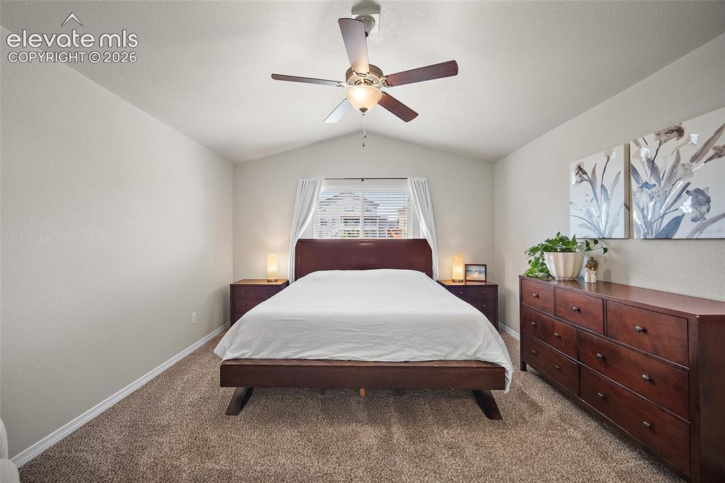 Image 17 of 50: Carpeted bedroom featuring an angled ceiling and a window with blinds