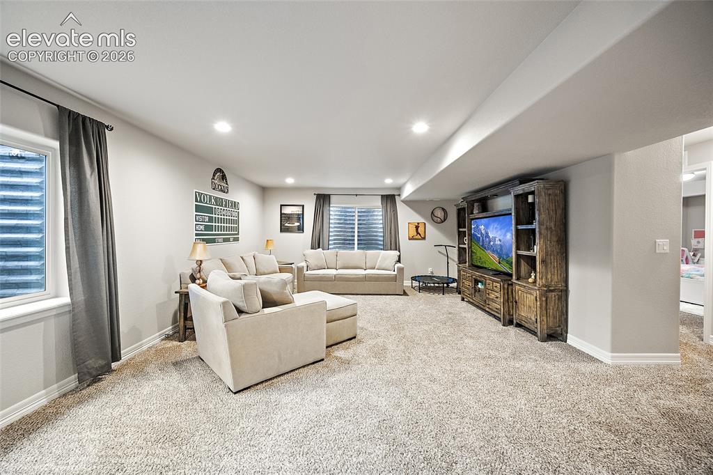 Image 22 of 49: Spacious room featuring neutral carpeting, recessed lighting, and a large b