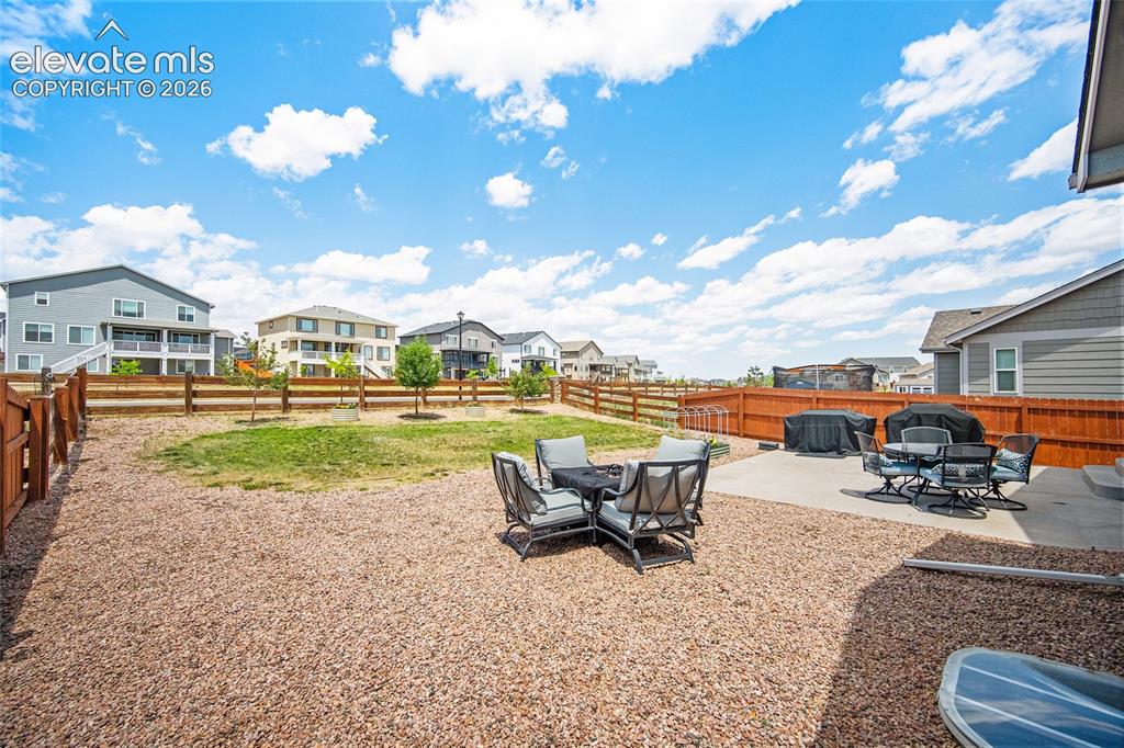 Image 33 of 49: Expansive backyard featuring a gravel-covered area, a rectangular concrete