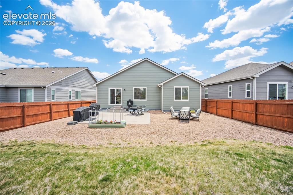 Image 37 of 49: Private backyard featuring a full perimeter privacy fence, a concrete patio