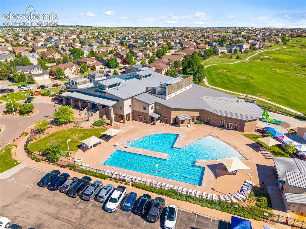 Image 38 of 49: Community center featuring a multi-lane swimming pool, expansive pool deck