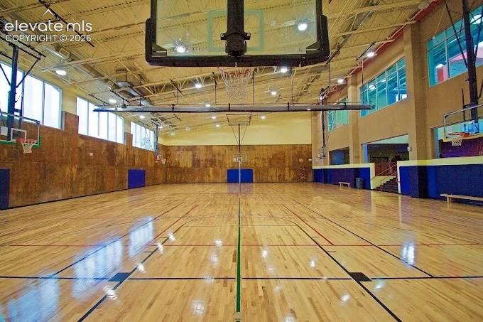 Image 41 of 49: Hardwood sports court featuring painted game lines, multiple basketball hoo