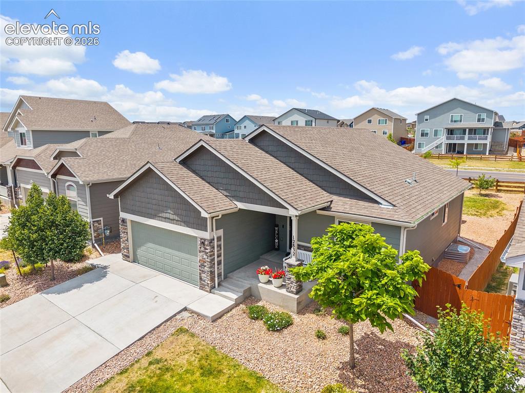 Image 46 of 49: Contemporary ranch-style residence featuring a gray exterior with stone acc