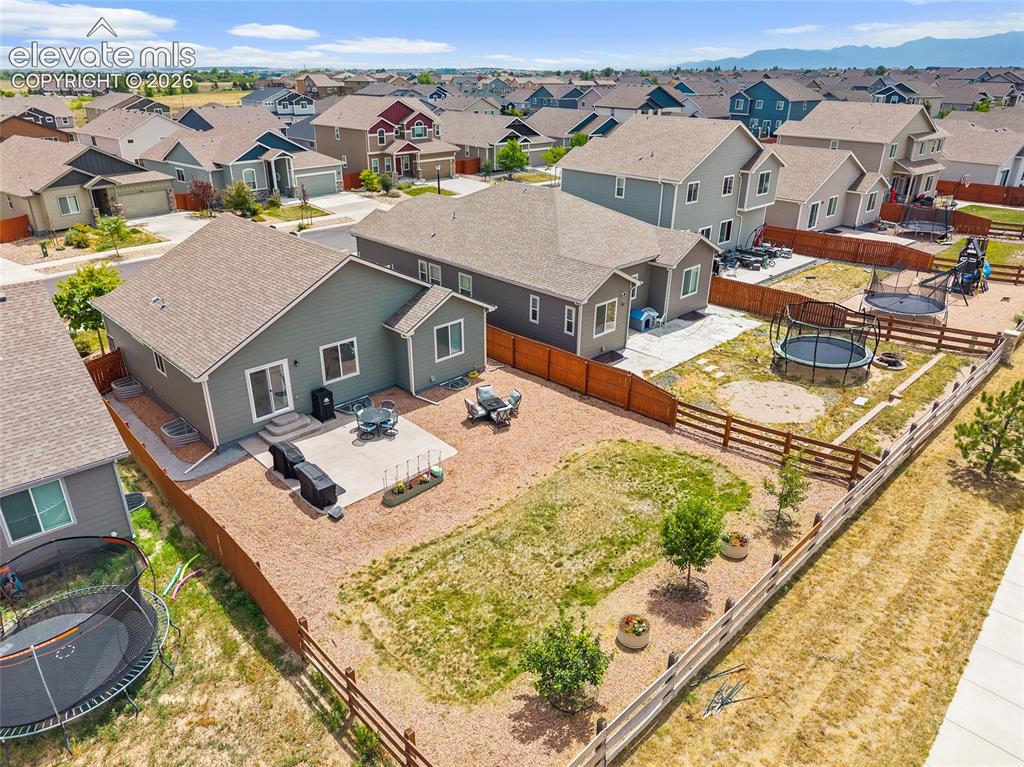 Image 8 of 49: Spacious backyard featuring a concrete patio, sliding glass door access, an