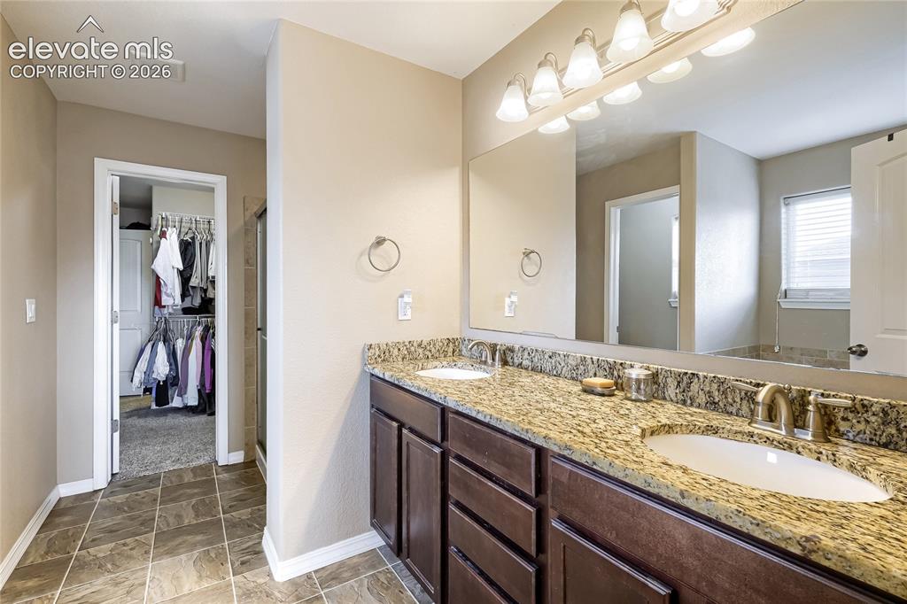 Image 15 of 32: Primary bathroom adjoins with this double vanity featuring granite countert