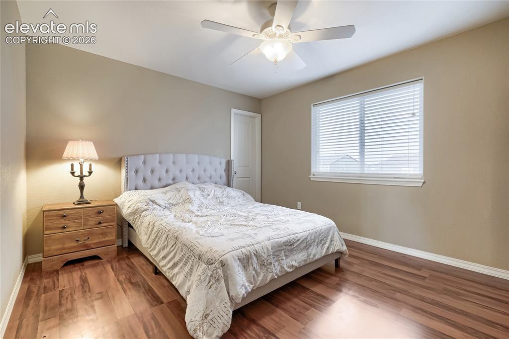 Image 19 of 32: 4th upper-level bedroom featuring wood-finish flooring, and walk-in closet