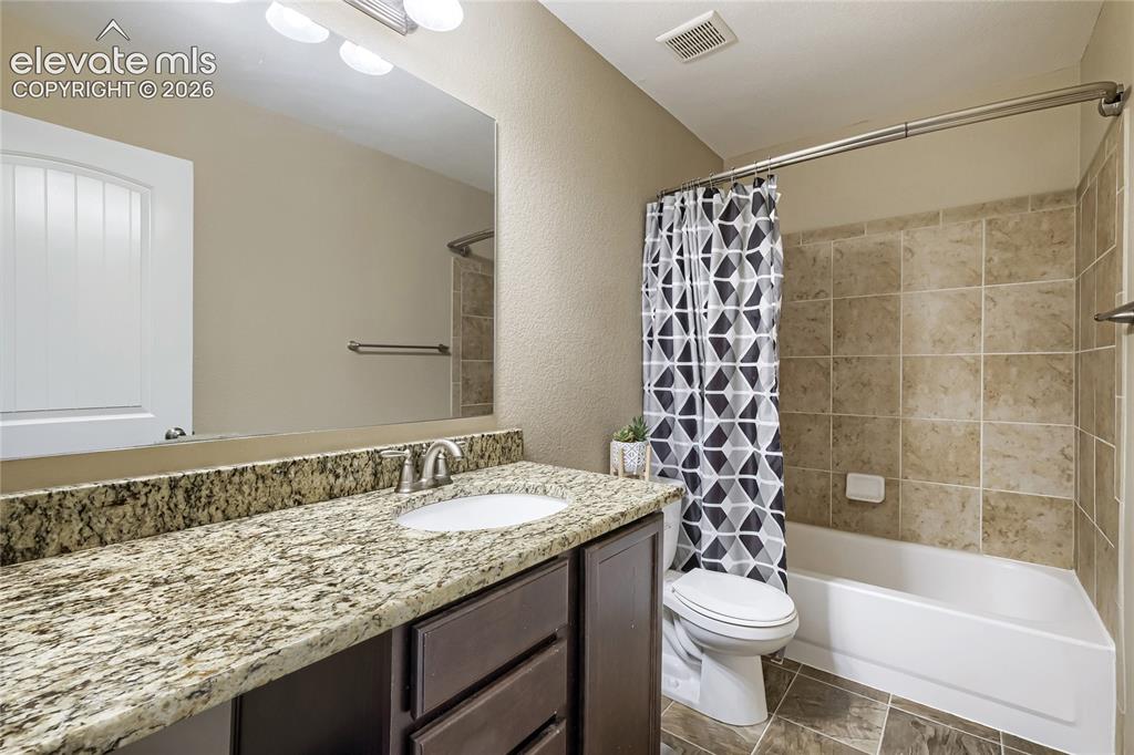 Image 21 of 32: Upper-level hall full bathroom featuring a vanity with a light-toned patter
