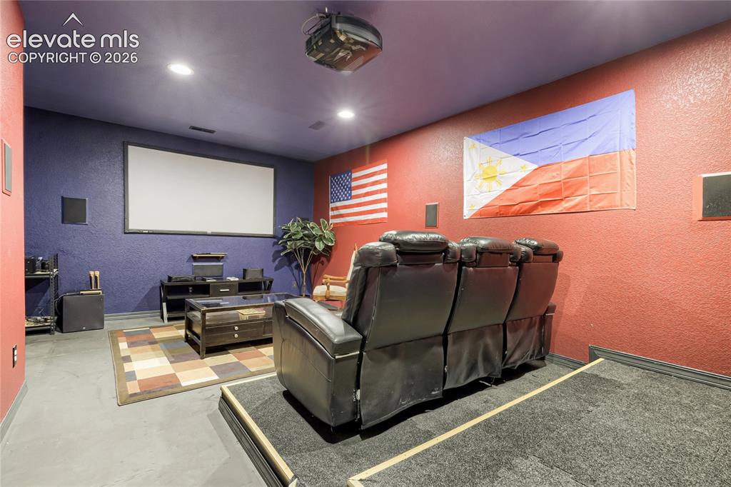 Image 24 of 32: Dedicated media room featuring a large projection screen, recessed lighting