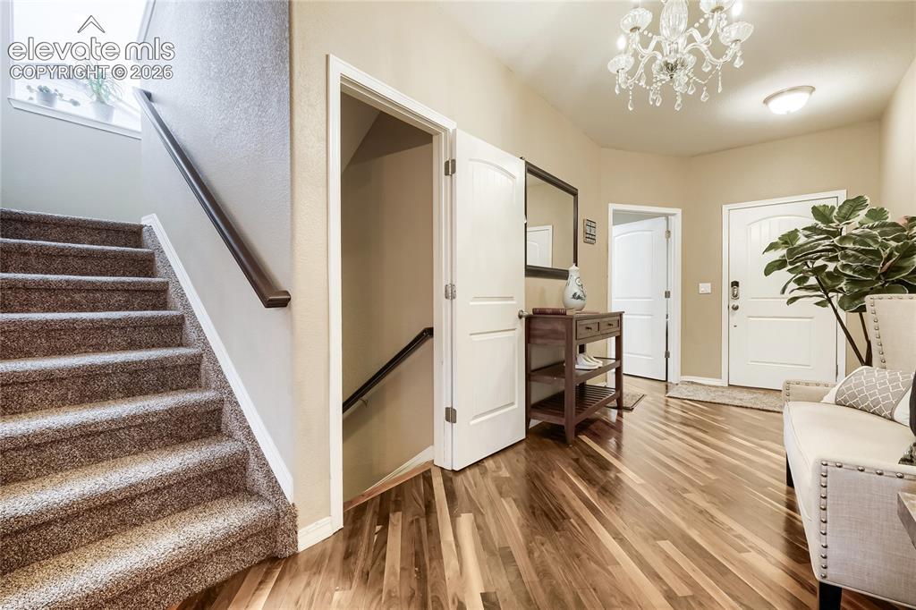 Image 3 of 32: Entryway featuring rich wood flooring, a contemporary crystal chandelier, a