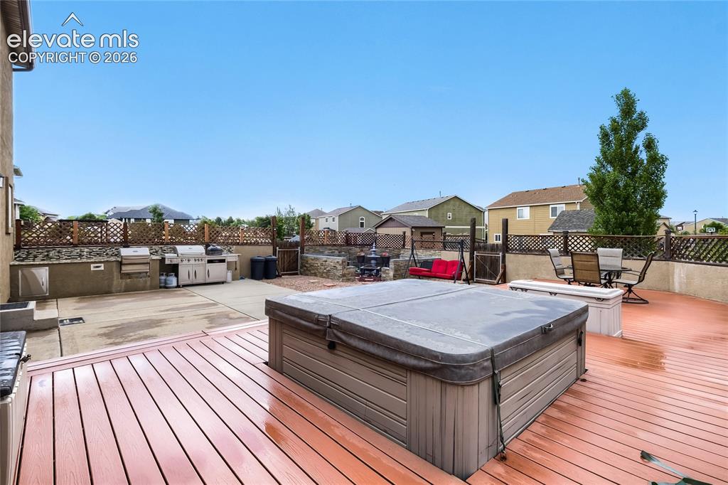 Image 30 of 32: Expansive outdoor living area featuring outdoor kitchen, a large, composite