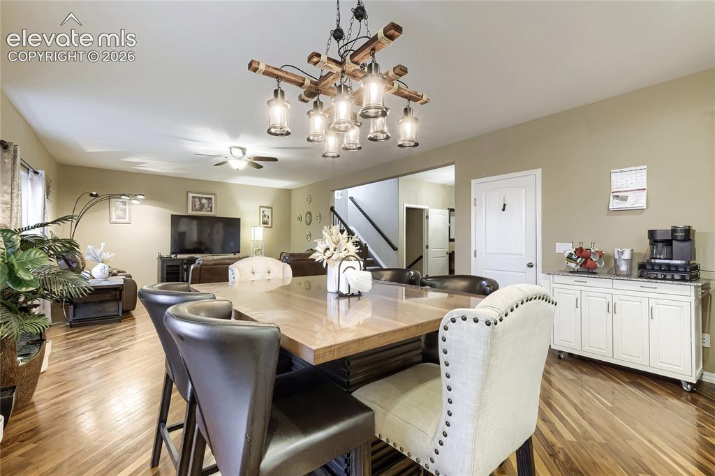 Image 7 of 32: Warm wood flooring extends through this open-concept space, featuring a dis
