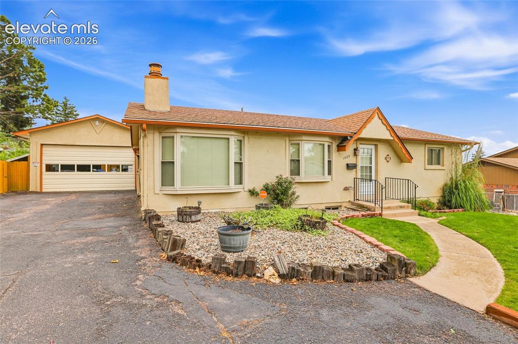 Image 1 of 43: Stucco exterior with a peaked roofline, an attached two-car garage, and a c