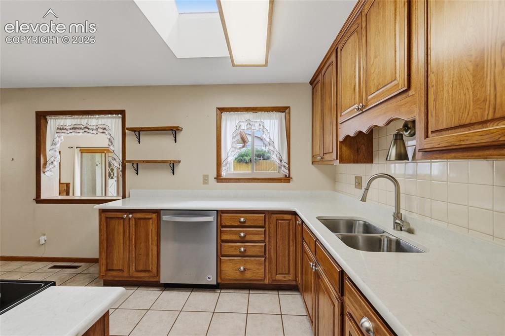 Image 14 of 43: U-shaped kitchen featuring wood cabinetry, solid surface countertops, a sta