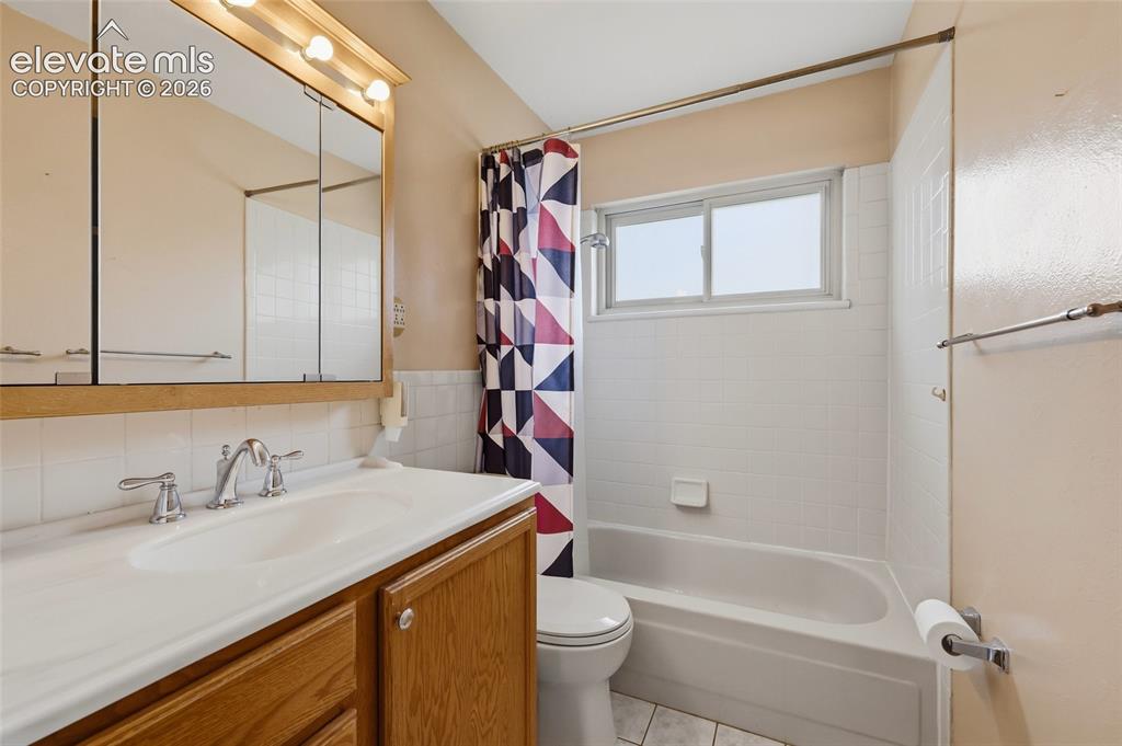 Image 18 of 43: Bathroom featuring a vanity with wood cabinetry, a white countertop, and a 