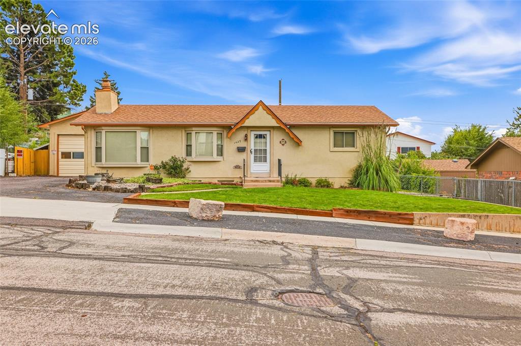 Image 2 of 43: Single-story residence featuring stucco siding, a gabled roof, and an attac