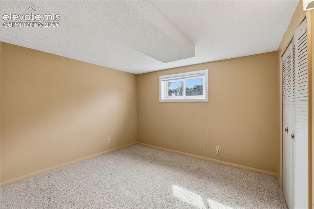 Image 21 of 43: Carpeted flooring, neutral wall tones, and a single window with white trim