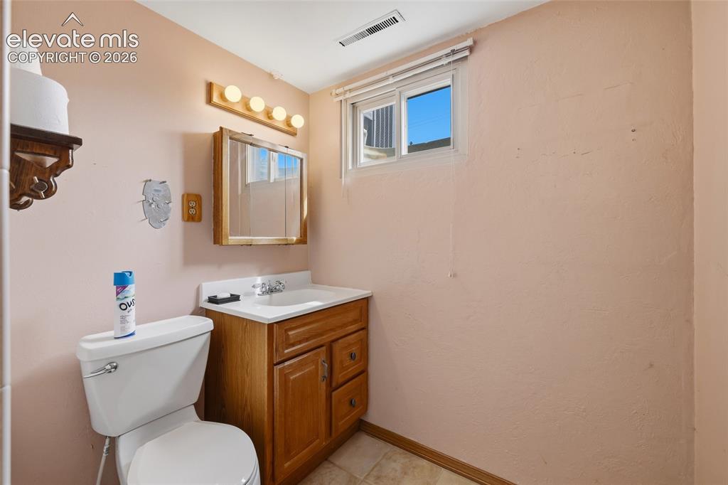 Image 23 of 43: Wood-finish vanity with an integrated basin, chrome faucet, and mirrored me