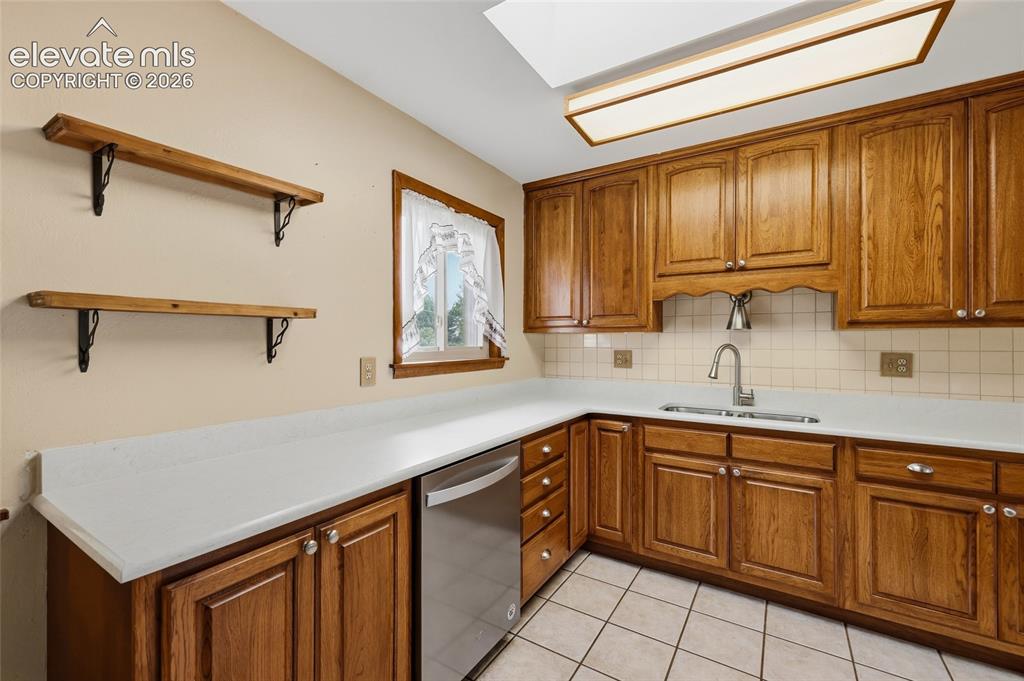 Image 5 of 43: Wood cabinetry with stainless steel hardware, white countertops, stainless
