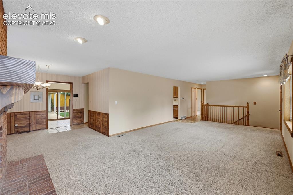 Image 9 of 43: Carpeted living space with recessed lighting and a brick fireplace