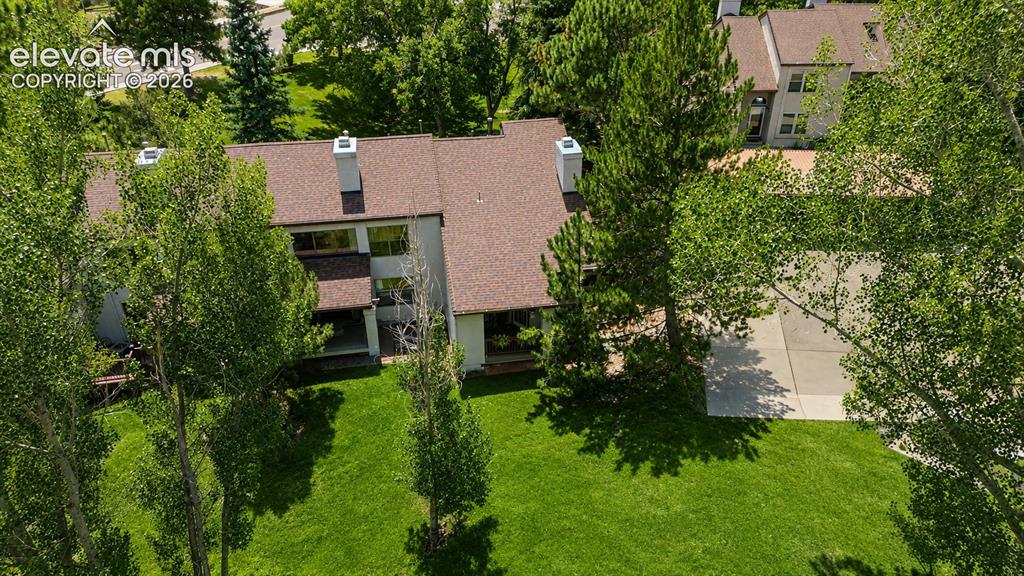 Image 26 of 27: Aerial view of home, park-like grounds and parking lot with reserved covere