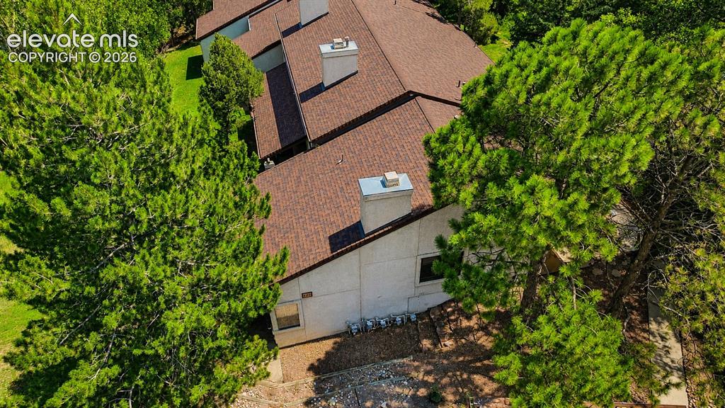 Image 27 of 27: Aerial view of complex and treed lot.