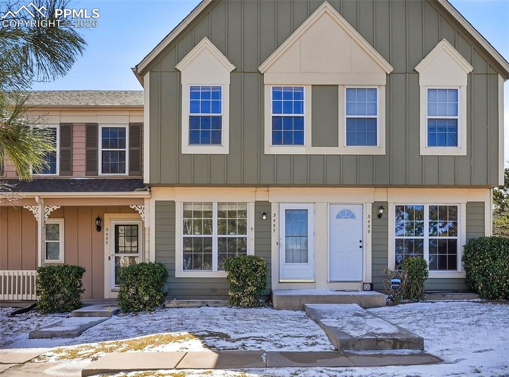 Caption: View of front of home with board and batten siding and a porch