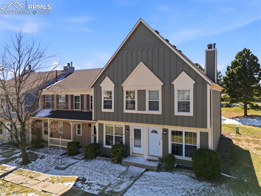 Image 2 of 44: View of front of house with board and batten siding, covered porch, and a c