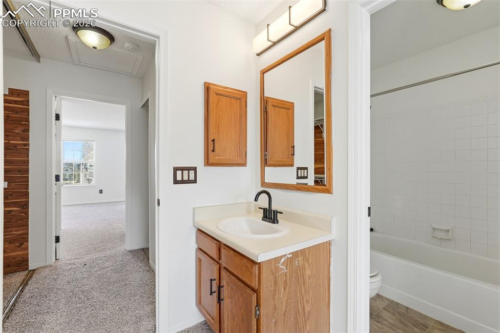 Image 21 of 44: Bathroom with vanity, bathtub / shower combination, and light colored carpe
