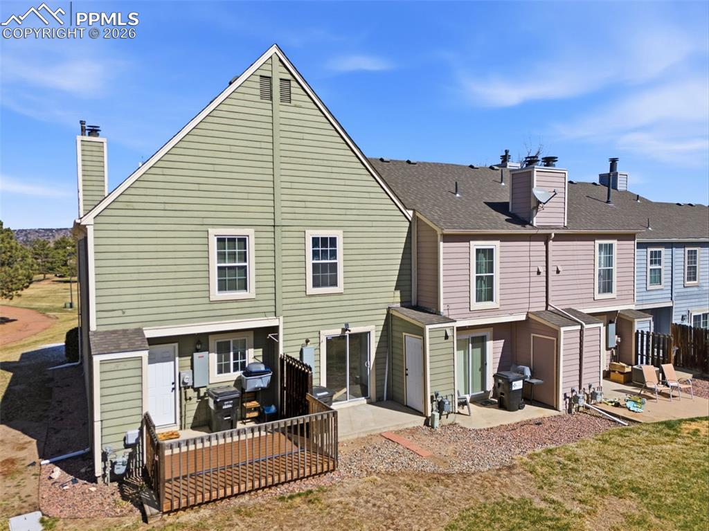 Image 41 of 44: Back of house with a patio area, a chimney, a shingled roof, and a resident