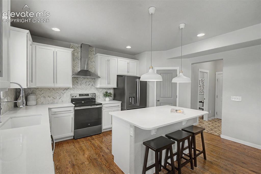 Image 13 of 40: Quartz counters, classic yet on-trend details: full backsplash, chic applia