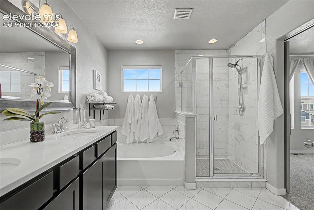 Image 21 of 40: Spa day, anyone?  Double quartz vanity, sumptuous tub, and wonderful hand-h
