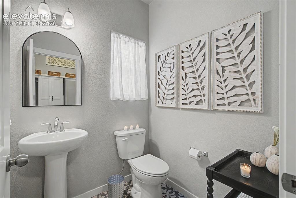 Image 36 of 40: The charming main floor powder room is privately located and simply lovely 