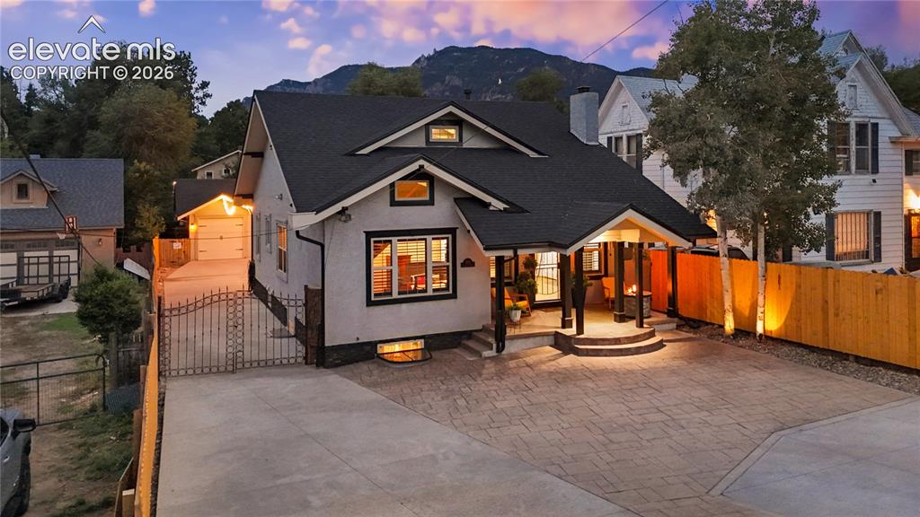 Caption: Craftsman-style exterior with a covered front porch, stone accents, and a dark shingle roof