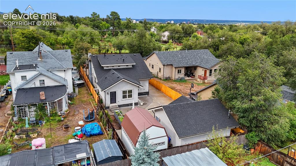 Image 16 of 45: Modern property featuring a light gray exterior, dark shingle roof, and a v