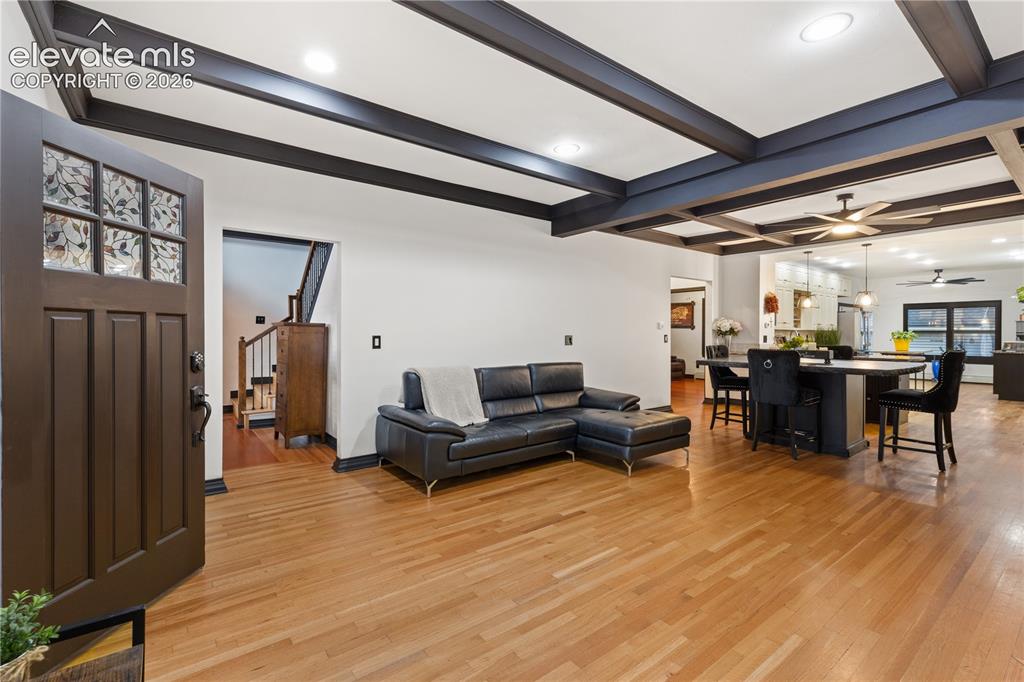 Image 17 of 45: Solid wood entry door with decorative glass, hardwood flooring, coffered ce