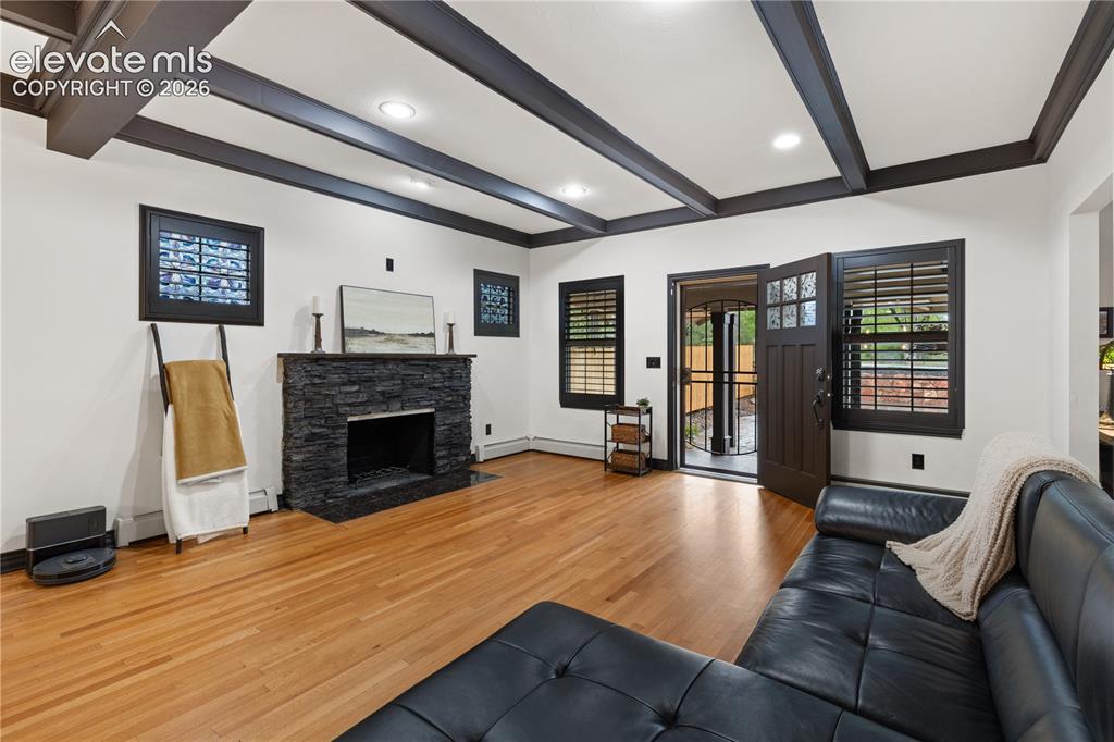 Image 18 of 45: Living space featuring wood-finish flooring, a stone-clad fireplace, and be