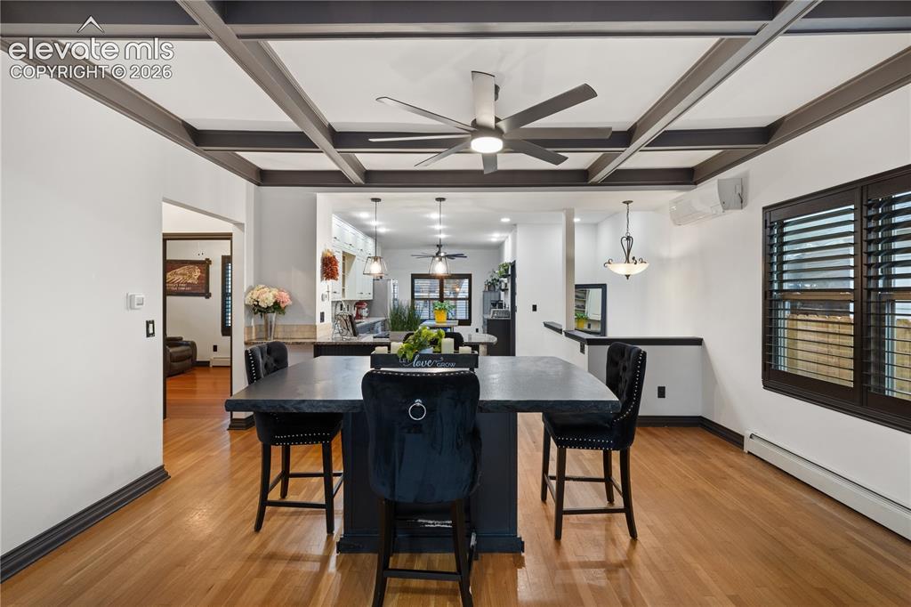 Image 20 of 45: Coffered ceiling with integrated ceiling fan, hardwood flooring, and custom