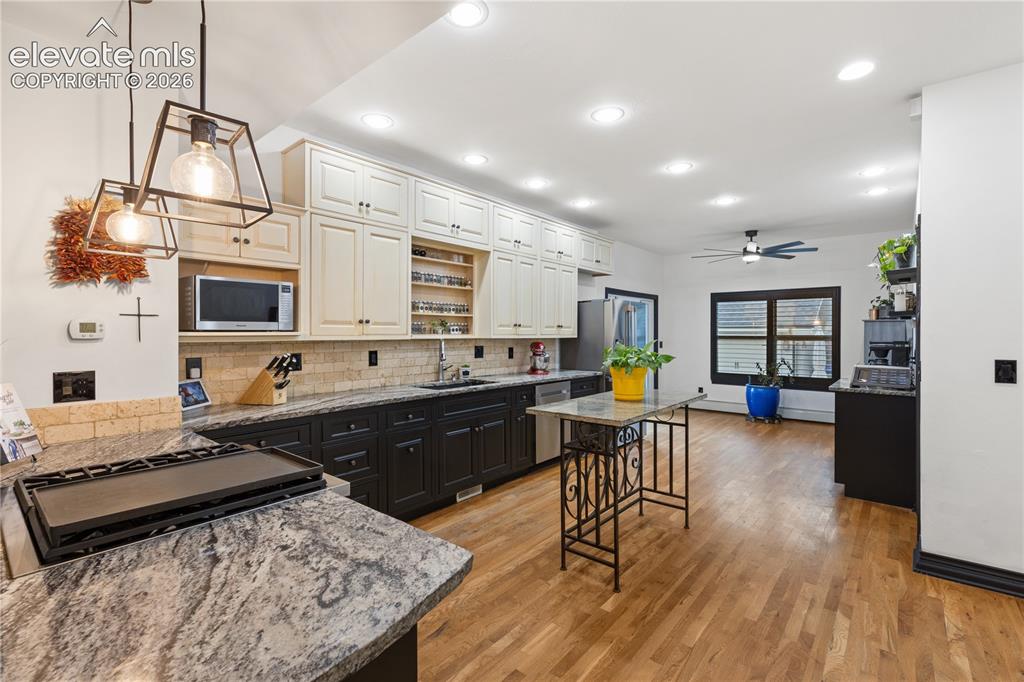 Image 21 of 45: Spacious kitchen featuring two-tone cabinetry with black base cabinets and