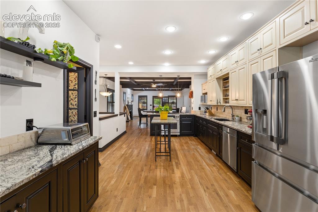 Image 24 of 45: Gourmet kitchen featuring wood-finish flooring, stainless steel appliances,